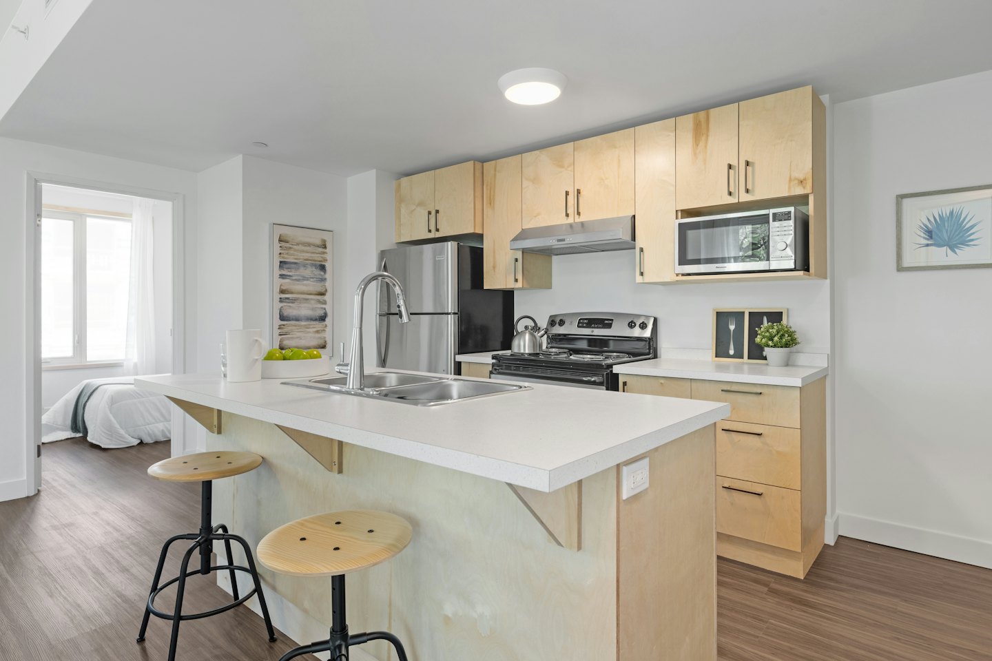Nowoczesna kuchnia w apartamencie z wyspą prowadzącą do sypialni.